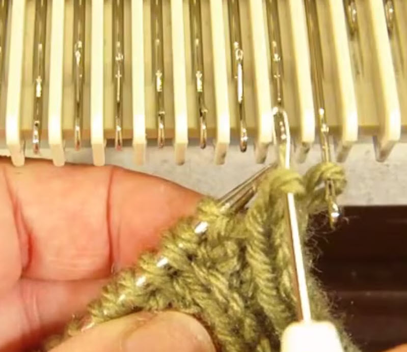 Hands holding knitting needles beside a close-up of a knitting machine
